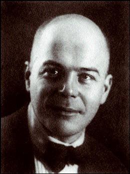 Black and white photograph of Viktor Shklovsky: a young man with a shaved head, in a dark jacket and bow tie, looking slightly away from the camera.